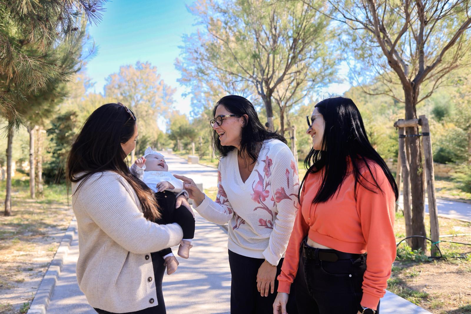 Deborah Schembri meeting a family outdoors
